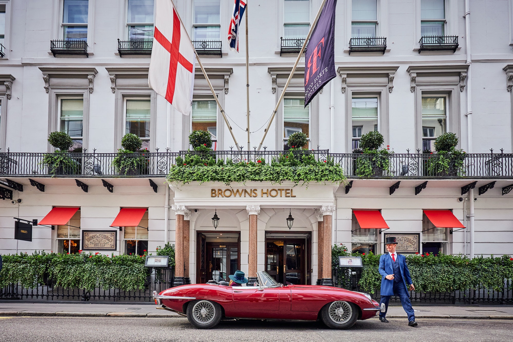 Red sports car arriving at Brown's Hotel, London, UK.